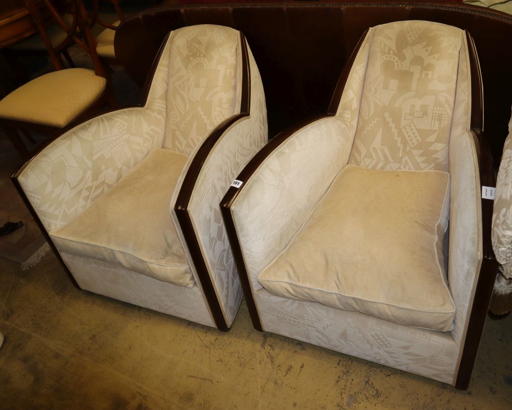 A pair of 1930s French Art Deco walnut framed armchairs, with deco design cream upholstery, W.69cm, D.85cm, H.63cm